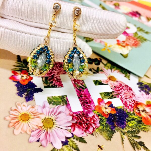 A pair of PrudenceC Gift Card earrings with flowers on them.