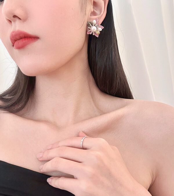 A woman wearing a black dress and a pair of E2110 earrings.