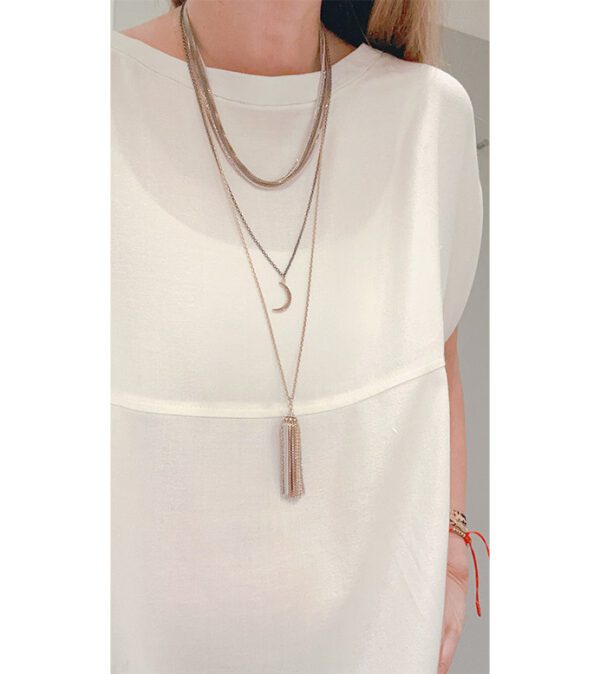 A woman wearing a white top and an NK890B necklace with tassels.