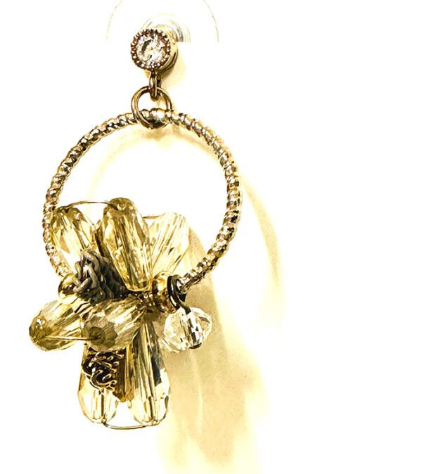 A gold hoop earring with a flower and crystals: The E2103 is a gold hoop earring with a flower and crystals.