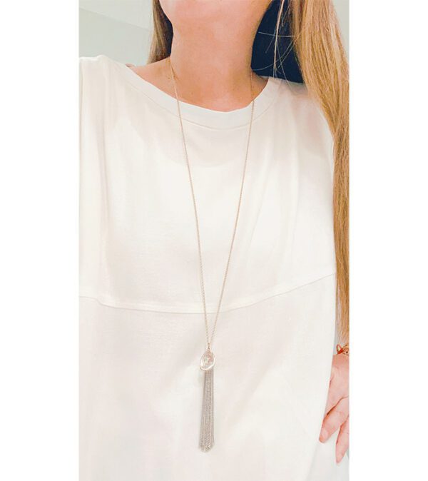 A woman wearing a white top with an NK8895 necklace.