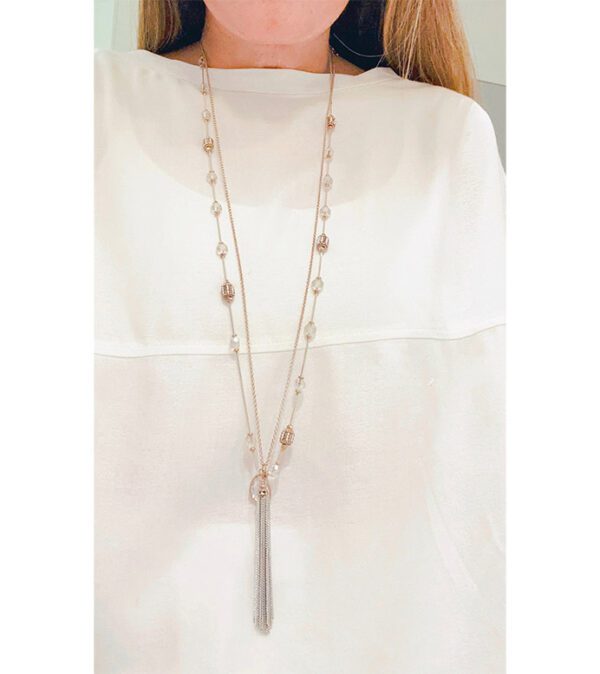 A woman is wearing a NK8895 necklace with a tassel.