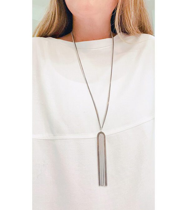 A woman wearing a white shirt with a black and white tassel necklace NK8636.