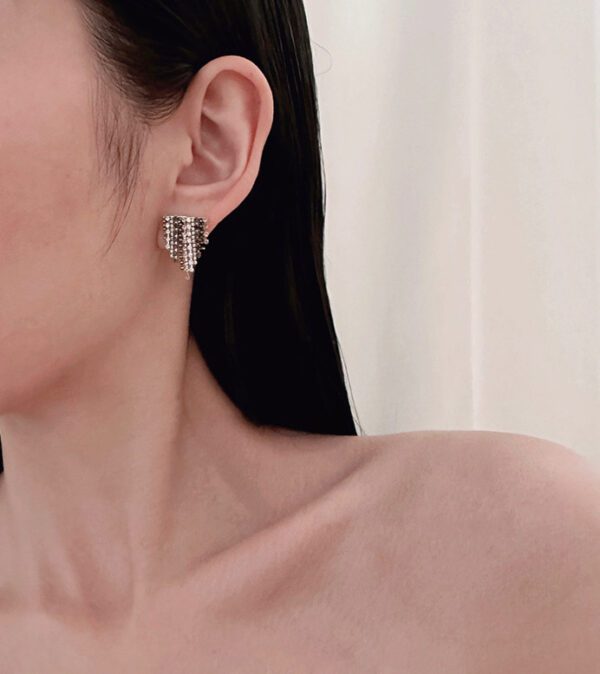 A woman with long black hair is wearing a pair of E2029 earrings.