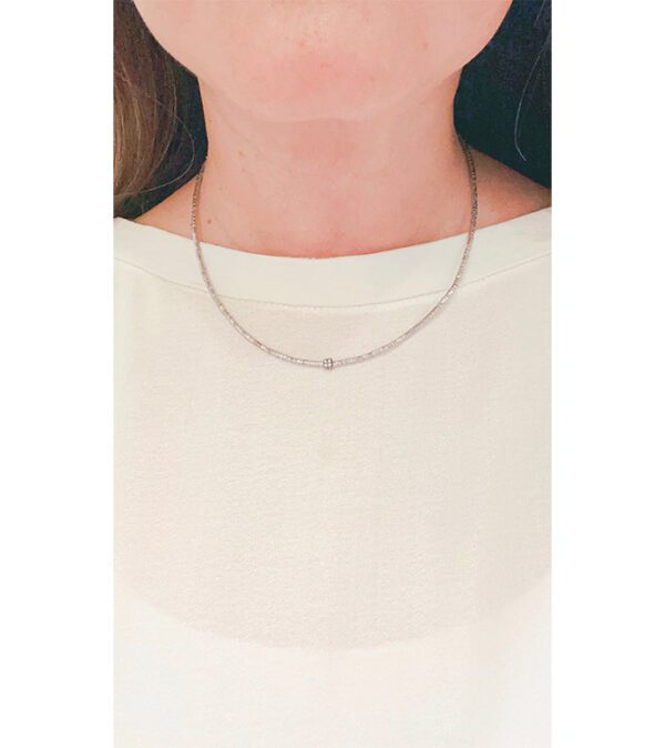 A close up of a woman wearing the NK5115 (Silver necklace).