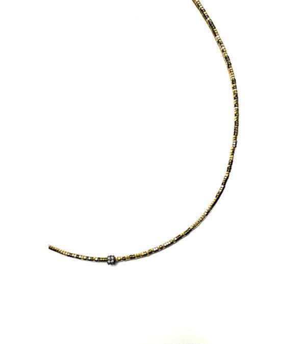 A NK5115 necklace with a diamond on it.