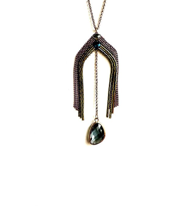 A NK4581 (Dark Berries) necklace with a blue stone hanging from a chain.