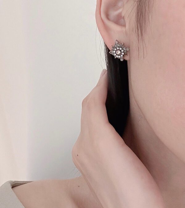 A woman wearing a pair of earrings with product name E0748.