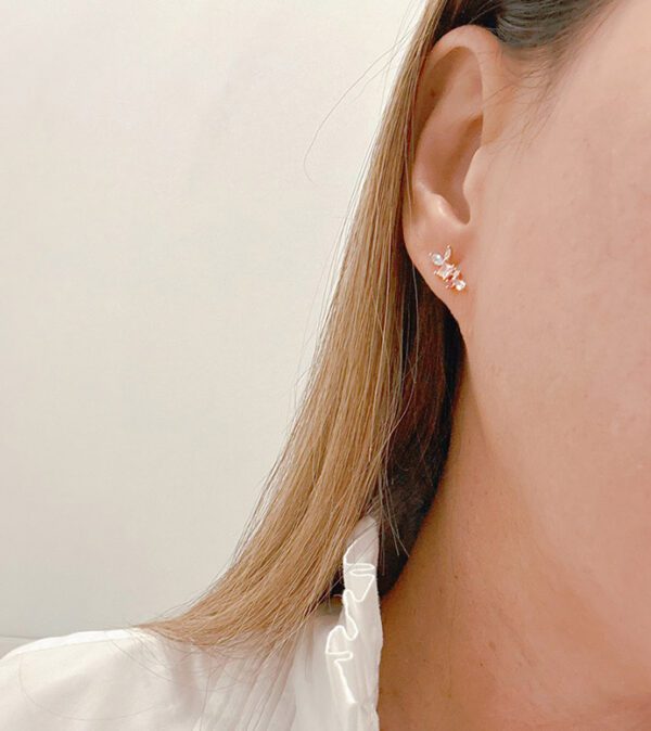 A woman wearing a white shirt and a pair of E0740 earrings.