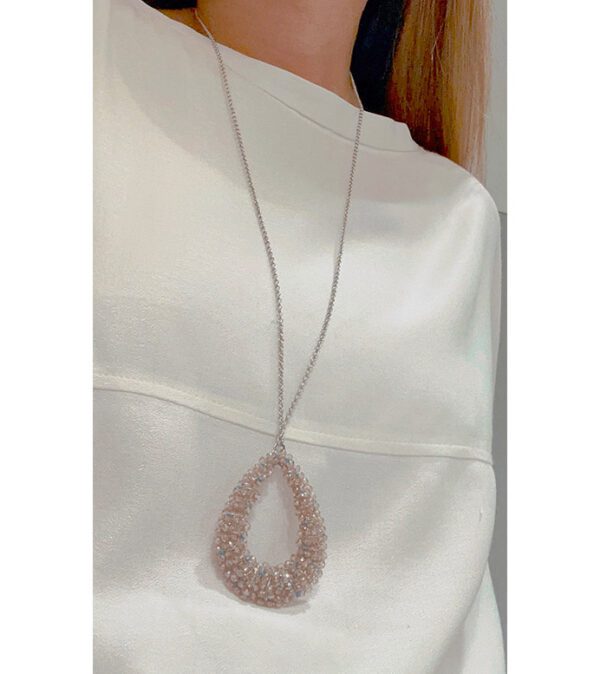 A woman wearing a white shirt and the NK1060 necklace.