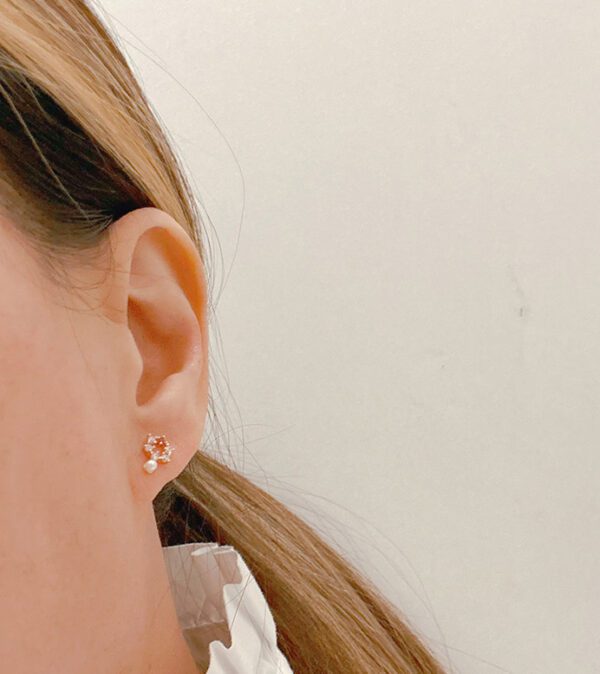 A woman wearing a white blouse and a pair of E0735 earrings.