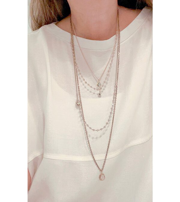 A woman wearing a white shirt and a NK0774 necklace.