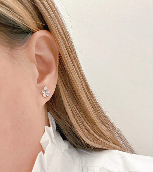 A woman wearing a white shirt and E0731 ear studs.