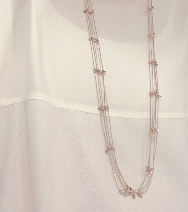 A white shirt with the NK333 necklace on it.