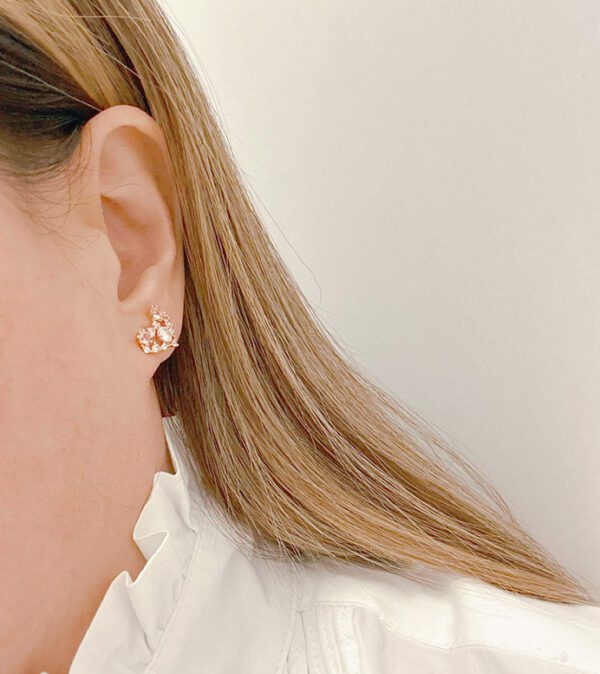 A woman wearing a white shirt and a pair of E0726 earrings.