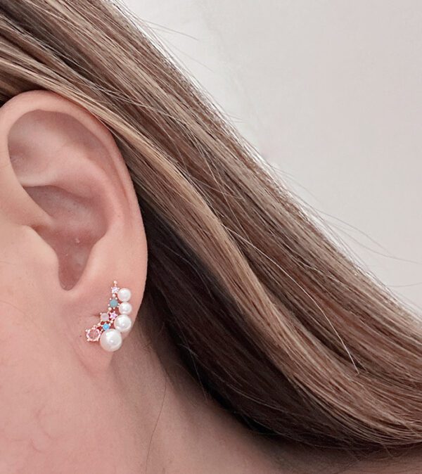 A woman's ear is decorated with E670 and crystals.