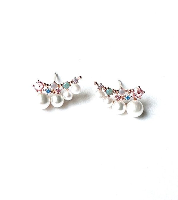 A pair of E670 earrings with pearls and crystals on a white surface.