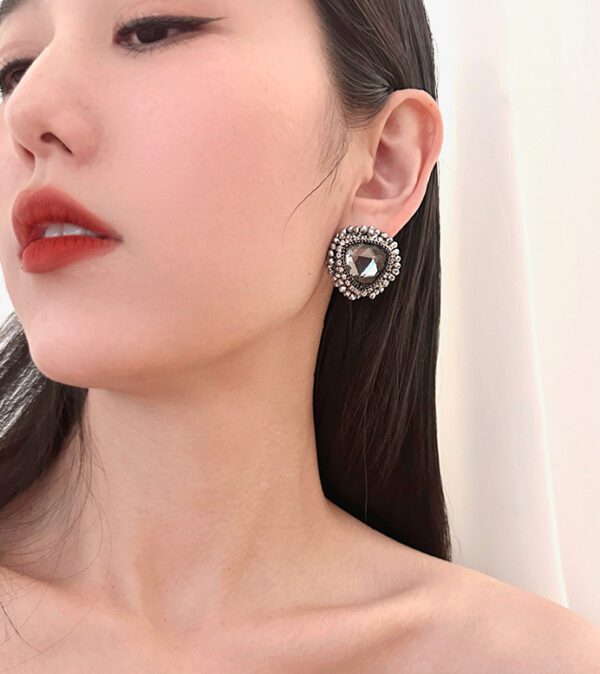 A woman wearing a pair of E81154 (Silver) earrings.