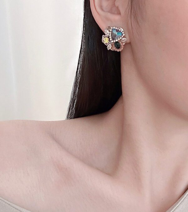 A woman wearing a pair of E24817 (Multi) earrings with crystals on them.