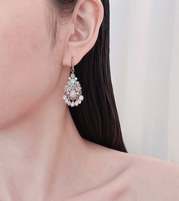 A woman wearing a pair of E24813 (Pastel) earrings with pearls and rhinestones.