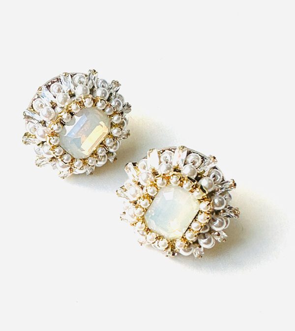 A pair of E24812 (White) stud earrings on a white surface.