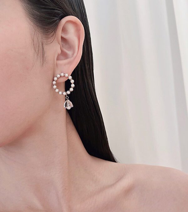 A woman wearing a pair of E24810 earrings.