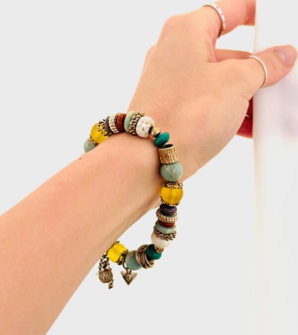 A woman's hand is holding a B5918 beaded bracelet.