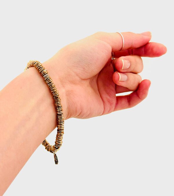 A woman's hand holding a B5098 beaded bracelet.