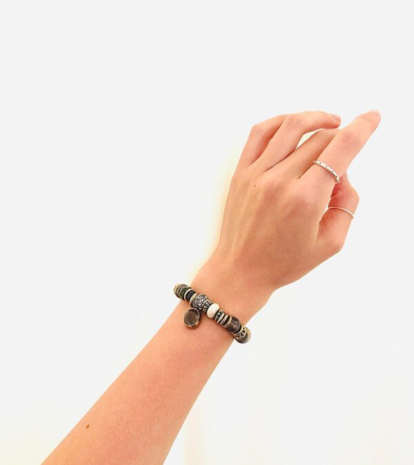 A woman's hand is holding a B3202 bracelet.