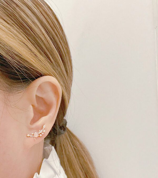 A woman wearing a white blouse and E8716 ear cuffs.