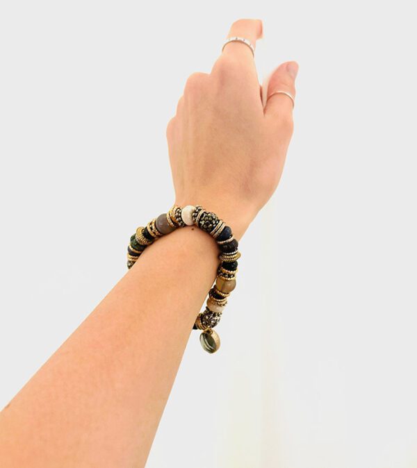 A woman's hand is holding a B3202 bracelet.