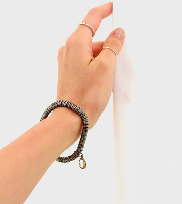 A woman's hand is holding a B1014 bracelet.