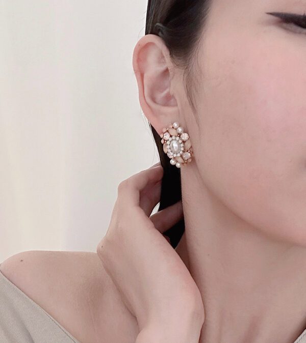 A woman wearing a pair of E8601 (Rose) earrings.