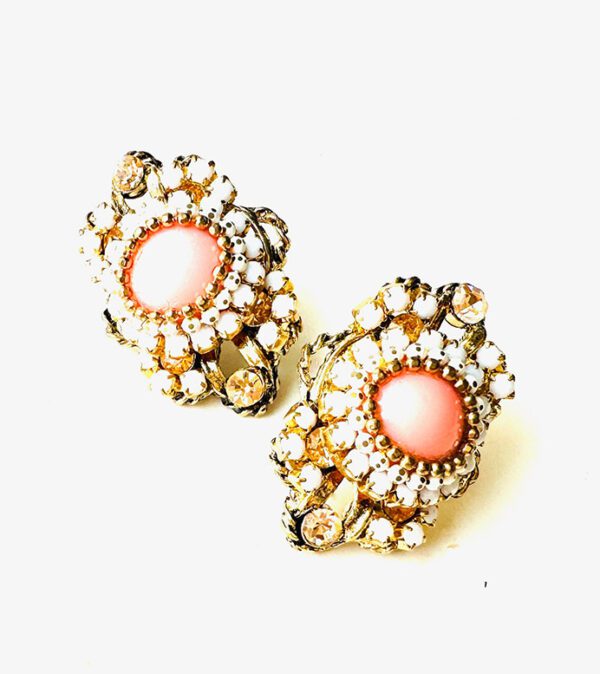 A pair of E8541 (Rose) earrings on a white surface.