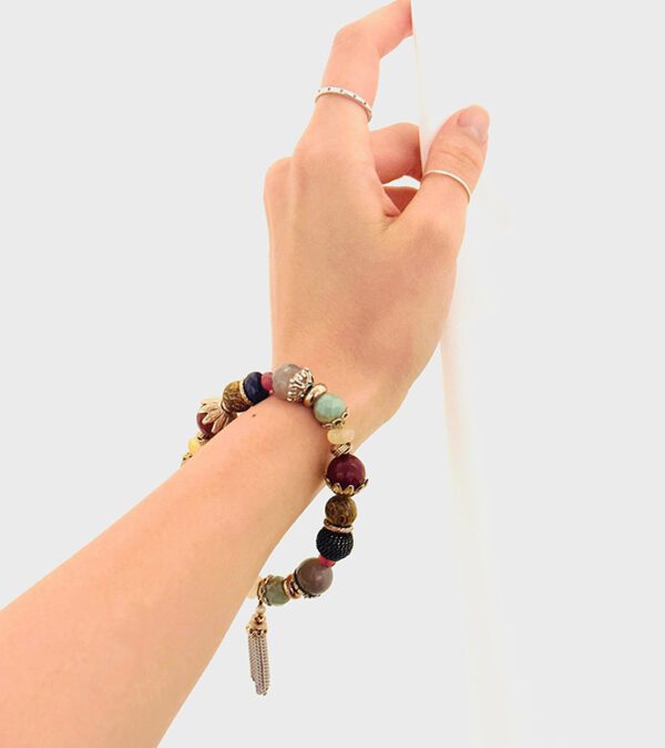 A woman's hand is holding a B0508 beaded bracelet.