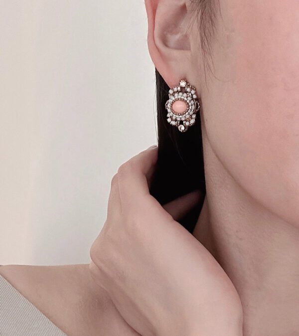 A woman wearing a pair of E8541 (Rose) earrings.