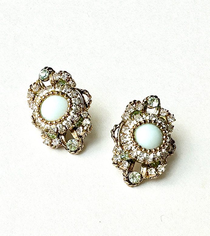 A pair of earrings with E8541 (Green) stones and rhinestones.