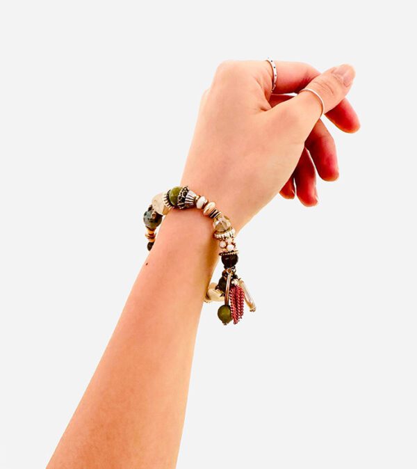 A woman's hand holding bracelet B0497 with beads on it.