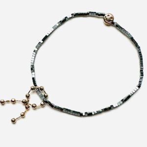 B208, a black beaded bracelet with a gold charm.