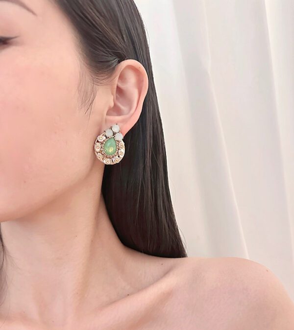 A woman wearing a pair of E8401 (Green Opal) earrings.