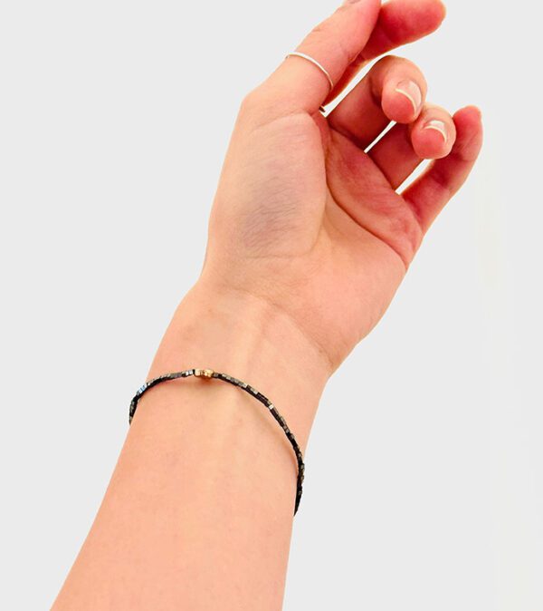 A woman's hand holding a B208 bracelet.