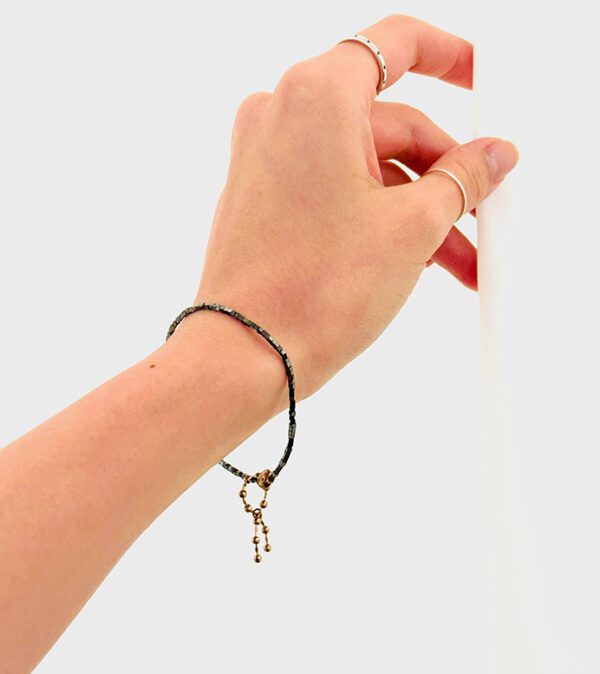 A woman wearing a B208 bracelet with a key on it.