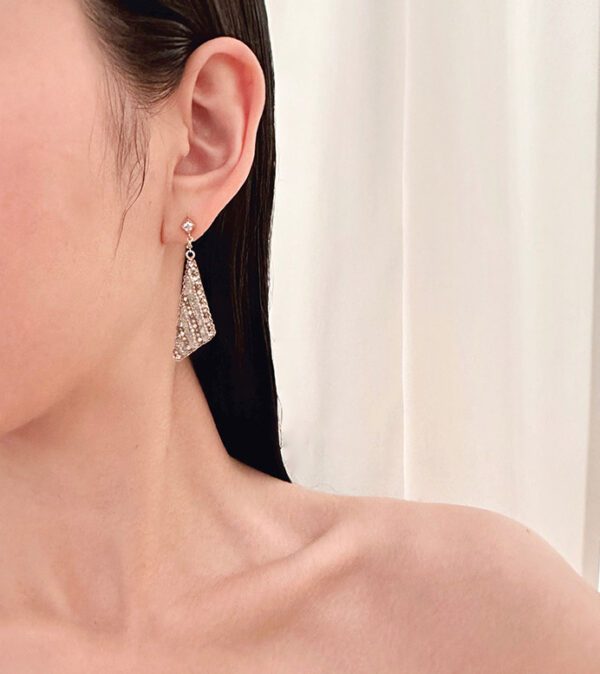 A woman wearing a pair of E5014 earrings with a triangle shape.