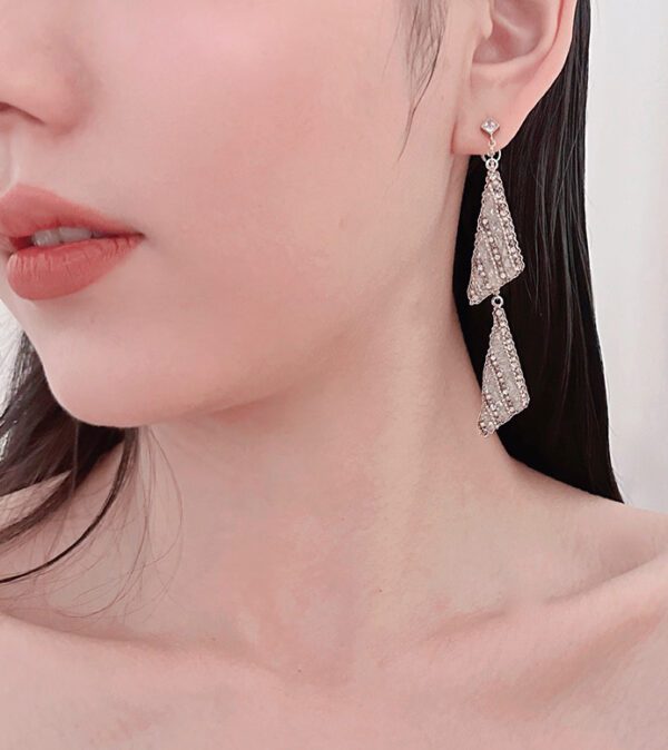 A woman wearing a pair of E5014 earrings.