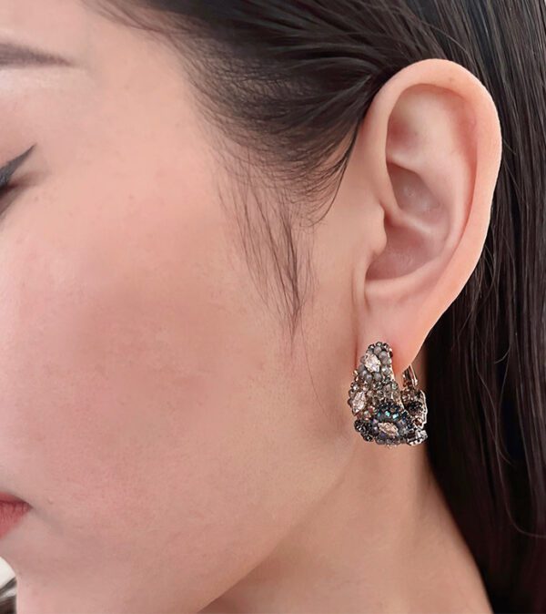 A woman wearing a pair of E5005 earrings.