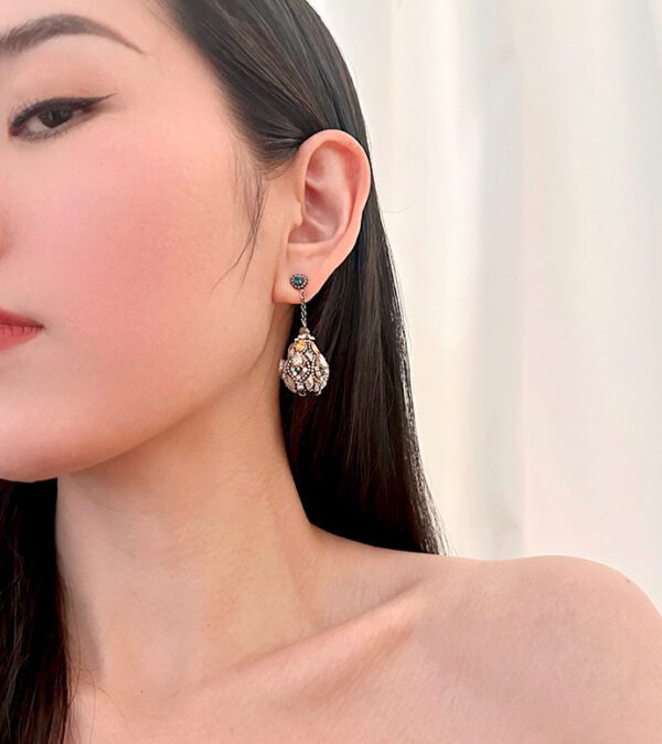 A young woman wearing a pair of E4140 earrings.