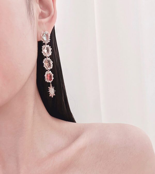 A woman wearing a pair of E3454 earrings with crystals.