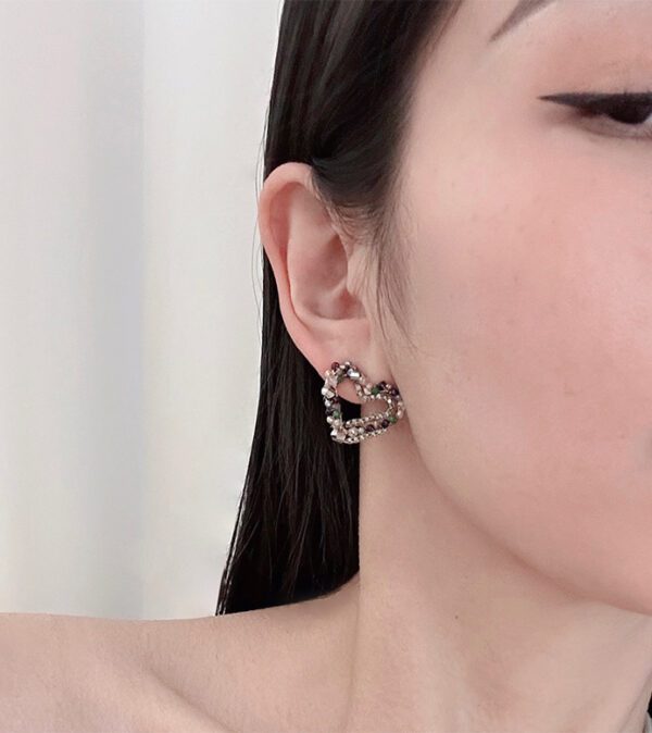 A woman wearing a pair of E2496 earrings with studs.