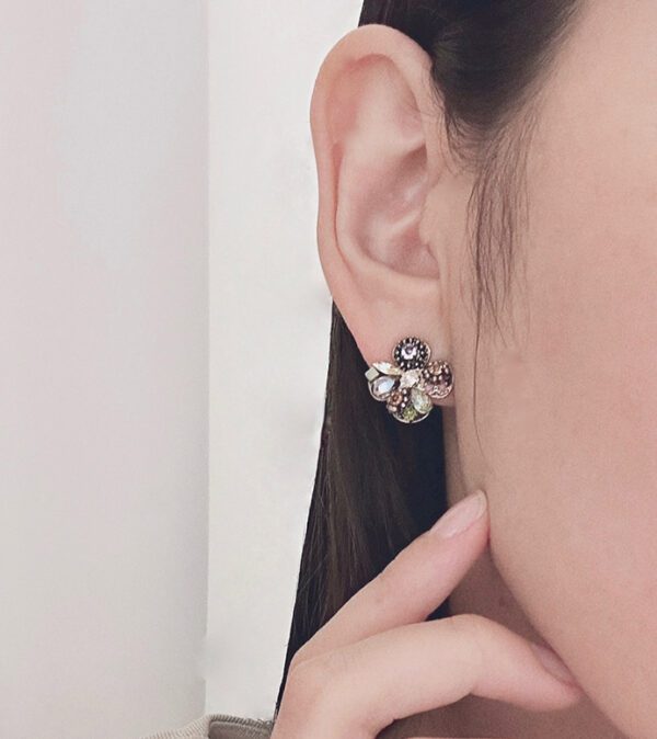 A woman wearing a pair of E2491 earrings with rhinestones.