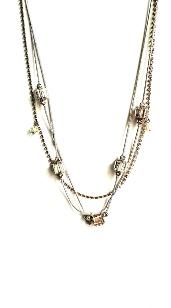 A three - strand NK1500 necklace with silver charms.